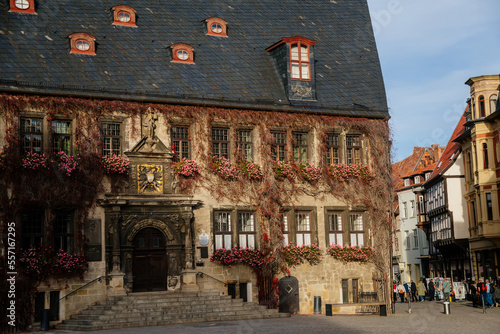 Quedlinburg, Saxony-Anhalt, Germany, 28 October 2022: Historic gothic townhall or Rathaus with Roland statue in Market Square, vintage colored timber frame houses in medieval town at sunny autumn day
