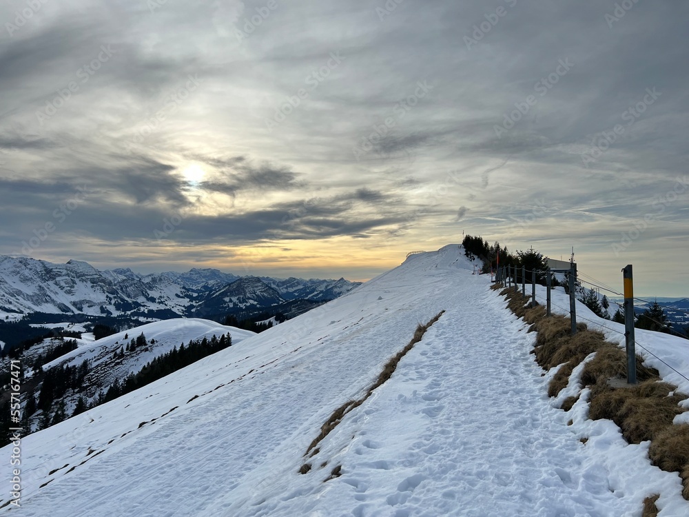 Late evening winter sun over the snow-covered slopes of the Alpstein mountain range and before dusk over massif of the Swiss Alps, Urnäsch (Urnaesch or Urnasch) - Canton of Appenzell, Switzerland Late evening winter sun over the snow-covered slopes of the Alpstein mountain range and before dusk over massif of the Swiss Alps, Urnäsch (Urnaesch or Urnasch) - Canton of Appenzell, Switzerland