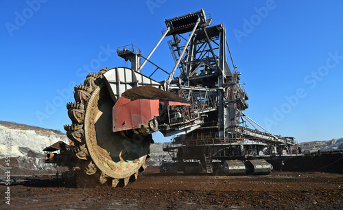 Bucket-wheel excavator during excavation at the surface mine. Huge excavator on open pit mine.	
