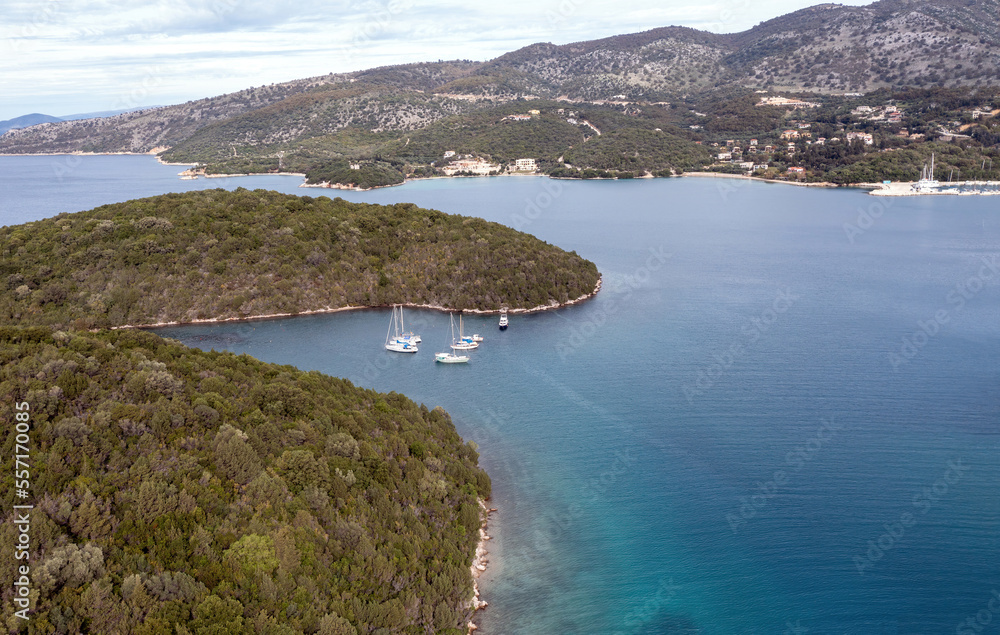 Fototapeta premium Sailboats anchored in a small bay in Epirus Ionian coast, aerial view. Sailing in Greece, near Sivota