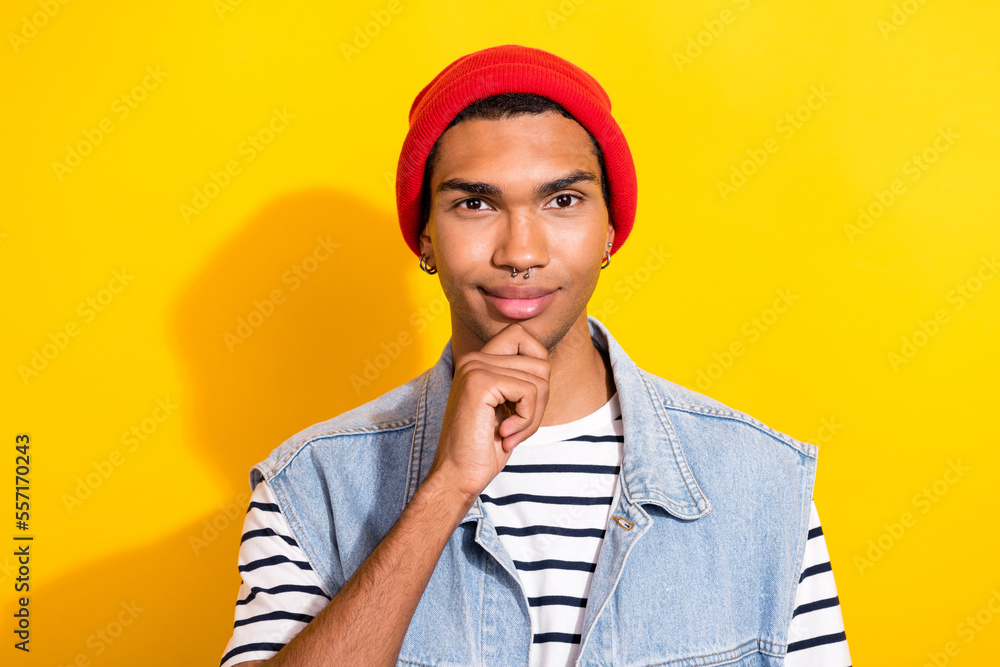 Portrait of creative clever person hand touch chin brainstorming red headwear isolated on yellow color background Portrait of creative clever person hand touch chin brainstorming red headwear isolated on yellow color background