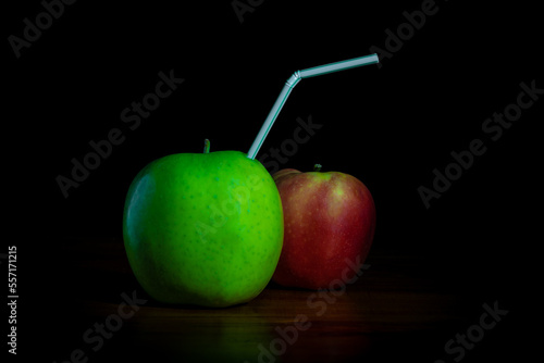 świeży sok jabłkowy w postaci rurki wbitej w owoc