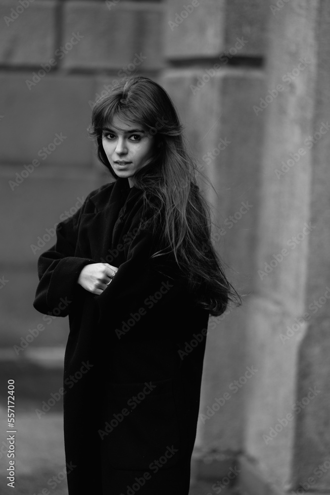 A young beautiful woman in a black coat