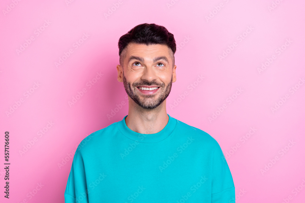 Photo of young cheerful smile positive man wear blue sweatshirt bristle beard look up interested useful information isolated on pink color background Photo of young cheerful smile positive man wear blue sweatshirt bristle beard look up interested useful information isolated on pink color background