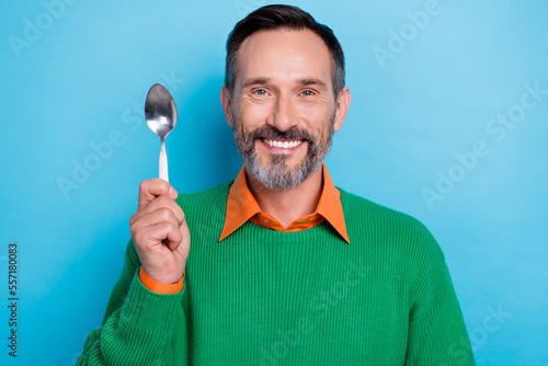 Portrait of cheerful smile mature age man enjoy new soup delicious recipe hold metal spoon want try this meal isolated on blue color background
