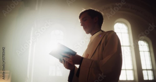 In Christian Church: Portrait of Minister Leading Congregation In Prayer, Reads From The Holy Book, The Bible, Gospel of Jesus. Priest Providing Guidance, Belief, Hope to People. Cinematic Warm Light photo