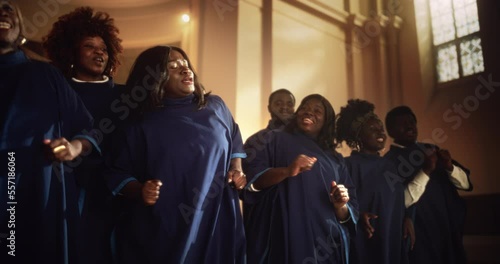 Black Christian Gospel Singers in Church Clapping and Stomping, Praising Lord Jesus Christ. Warm Atmosphere in Church Thanks to Energetic Choir Singing Uplifting Music with Emotions and Happiness