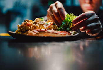 chef decorated plate with food on kitchen