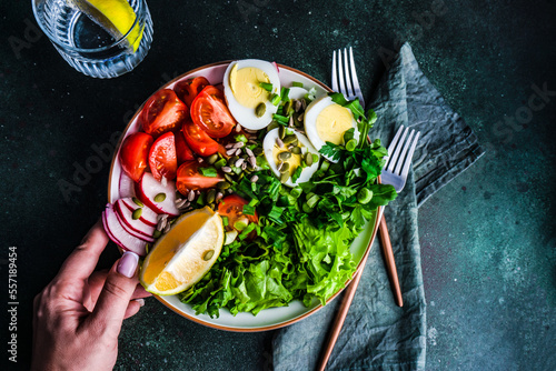 Anonymous person eating healthy raw vegetable salad