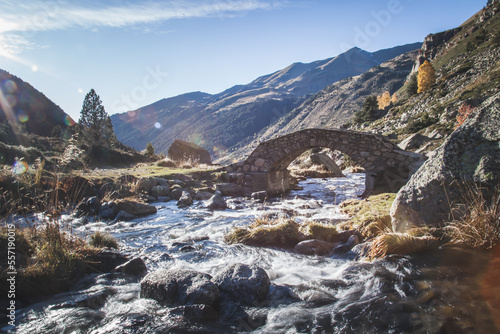 A old historical stone bridge passing over a river in the mountains of Andorra