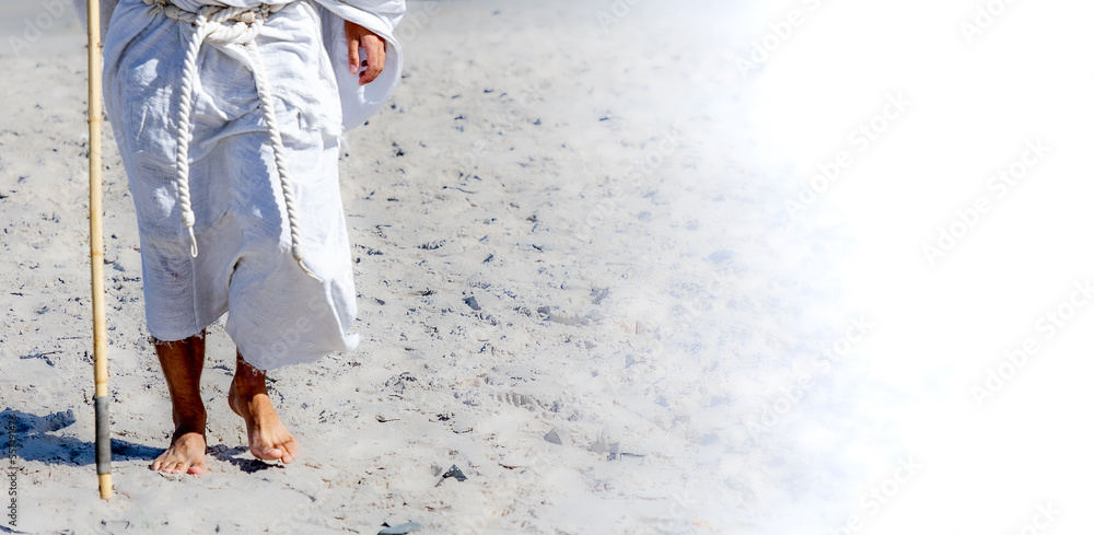 biblical man (like Jesus) walking in desert showing legs with copy space
