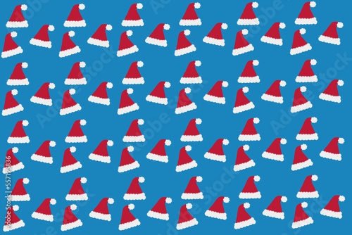 Red and white mini Santa hat floating on blue background with copy space. Christmas and New Year celebration concept. Creative party seamless pattern idea. Trendy winter holidays layout..