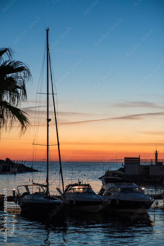 Sunset over the sea with sailboat silhouette