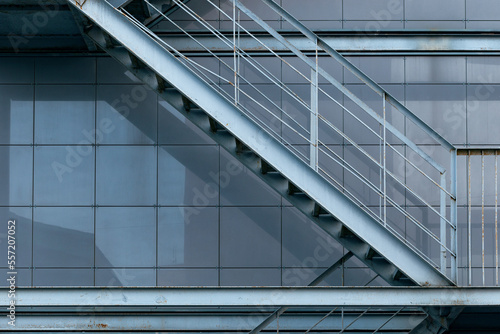 Tela Close-up of a metal fire escape staircase, facade of building in grey metal tiles