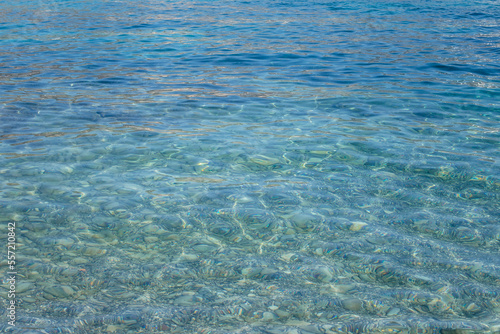 Texture of turquoise sea water with stones