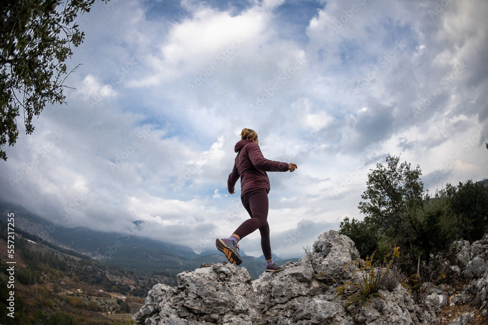 Successful female hiker hiking on a mountain peak. Successful female hiker hiking on a mountain peak.