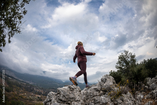 Successful female hiker hiking on a mountain peak. © zhukovvvlad