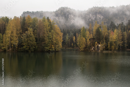 Romantic view of a mountain lake, beautiful turquoise water, mist spread over trees, lake surrounded by cliffs and rocks, Rock Town nature reserve in the Czech Republic