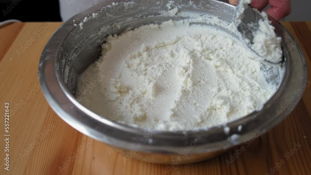the process of cooking tiramisu. a spoon levels the crushed cottage cheese. crushed cottage cheese. cottage cheese in a plate the process of cooking tiramisu. a spoon levels the crushed cottage cheese. crushed cottage cheese. cottage cheese in a plate