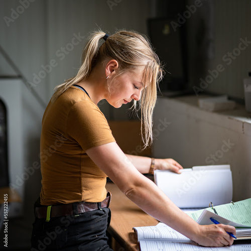 Auch Büroarbeit muß eine junge Landwirtin können, junge Landwirtin notiert und schaut einiges nach. photo