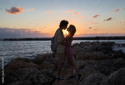young adults in love, a teenager boy and girl hugging at sunset on the coast, in anticipation of a kiss. enjoyment of the moment, tender feelings, pleasant pastime. Valentine's Day together