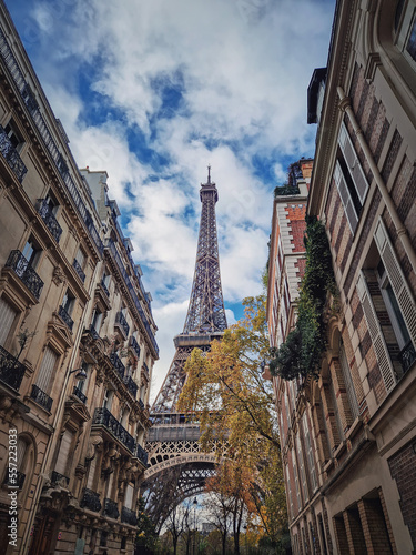Eiffel tower as seen through the parisian buildings. Snenery autumn season in Paris, France..