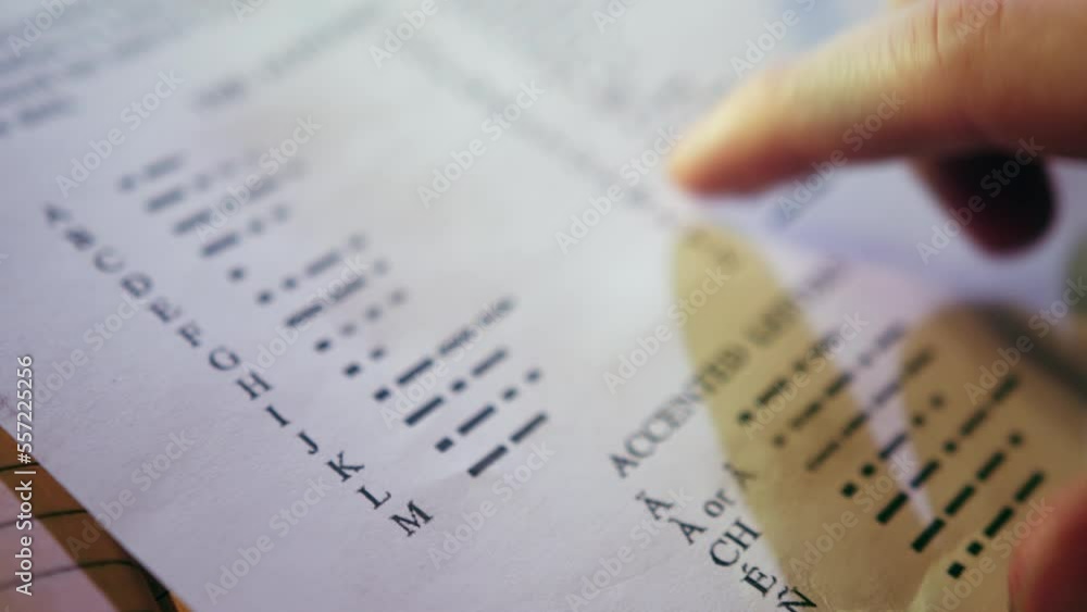 man-points-finger-on-morse-code-alphabet-on-page-of-educational-book