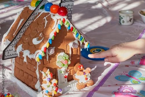 mom and daughter making a gingerbread house on christmas