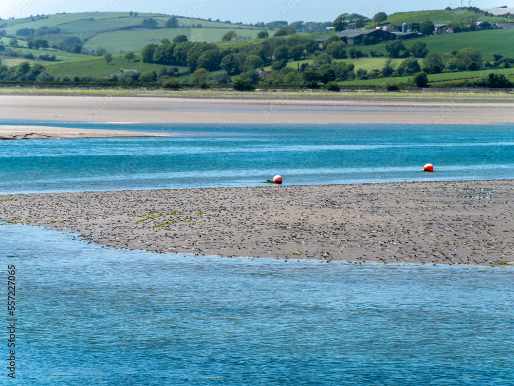 A sandbank at low tide on a sunny spring day. The sea water is a beautiful turquoise color. Sea coast, landscape.