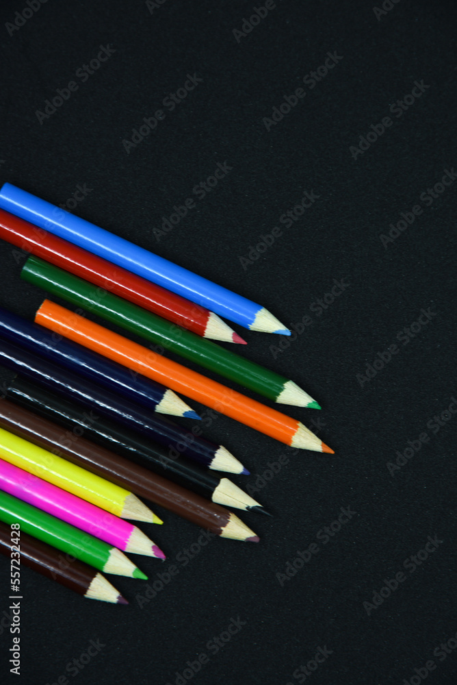 Colored pencils on a black background. Small pencils close-up. Colored pencils on a black background. Small pencils close-up.