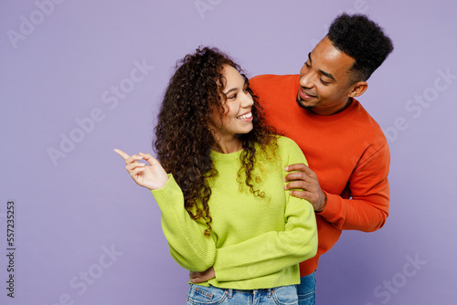 Фотография Young happy fun lovely couple two friends family man woman of African American ethnicity 20s wearing casual clothes together husband hug smiling wife isolated on pastel plain light purple background