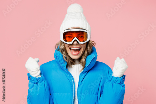 Snowboarder happy fun woman in blue suit goggles mask hat ski padded jacket do winner gesture celebrate isolated on plain pastel pink background Winter extreme sport hobby weekend trip relax concept