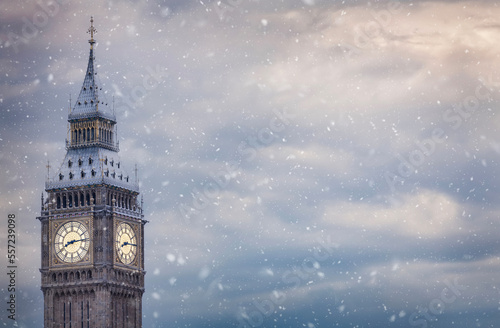 The ice covered Elizabeth Tower or so called Big Ben at Westminster Palace in London with snow and clouds as a background with copy space