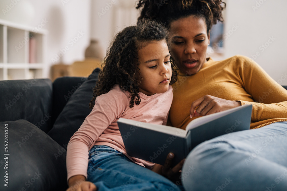 Mother reads a story to her daughter Mother reads a story to her daughter