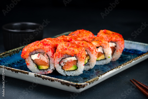 Set of sushi rolls with tuna tartare, salmon, crab sticks, cream cheese, avocado, red flying fish caviar and soy sauce.