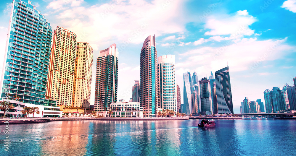 Scenic view of Dubai Marina in the largest city in the United Arab Emirates against the backdrop of skyscrapers with a boat.