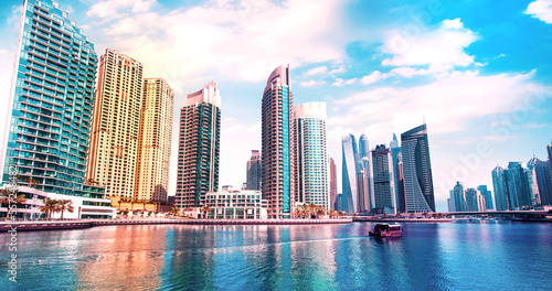 Obraz na płótnie Scenic view of Dubai Marina in the largest city in the United Arab Emirates against the backdrop of skyscrapers with a boat. w salonie