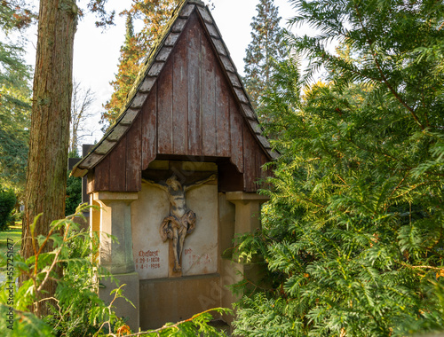 Fototapeta Naklejka Na Ścianę i Meble -  Überdachter Grabstein mit der Jesusfigur am Kreuz auf einem Friedhof in Osnabrück