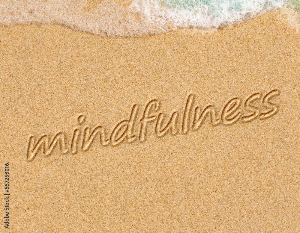 Fototapeta premium mindfulness concept, mindful living, text written on the sand of beach