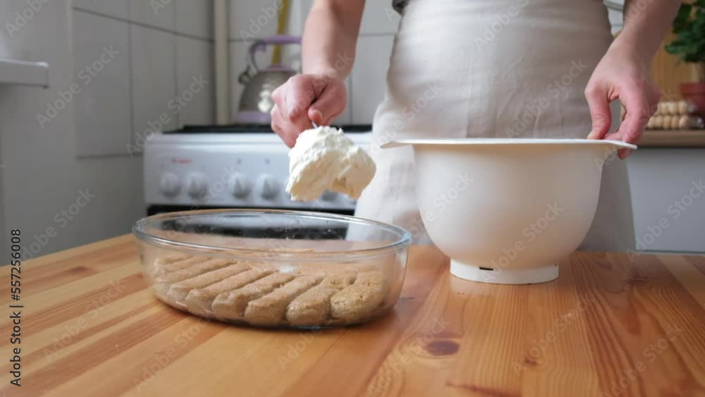 the process of cooking tiramisu. the cook lays out and smears