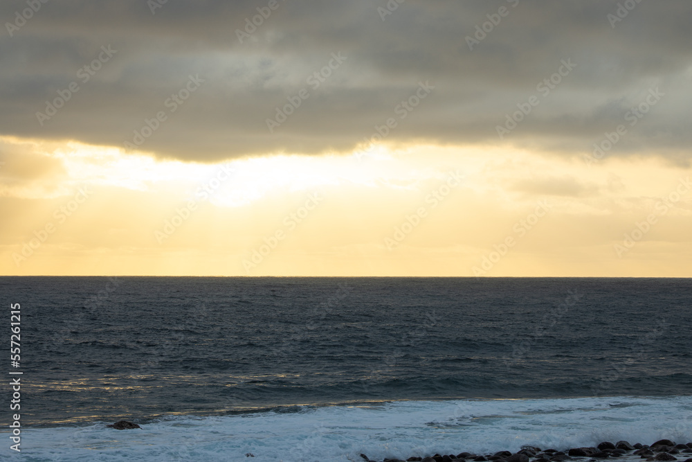 Huge waves on a beautiful morning in Madeira, Portugal. Great sunrise and a beautiful yellow sky over the tsunami.