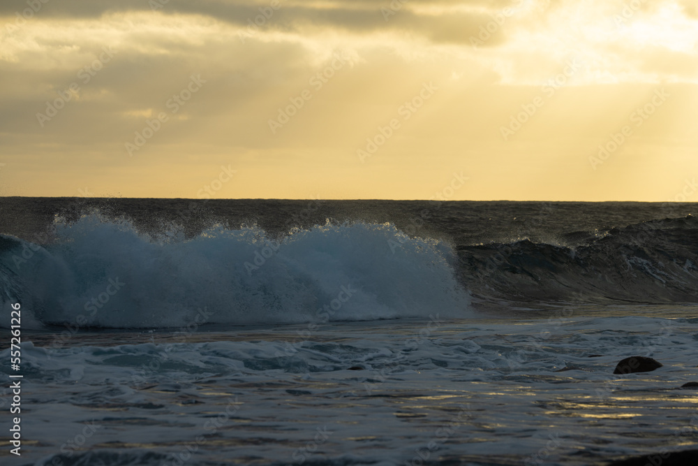 Huge waves on a beautiful morning in Madeira, Portugal. Great sunrise and a beautiful yellow sky over the tsunami.