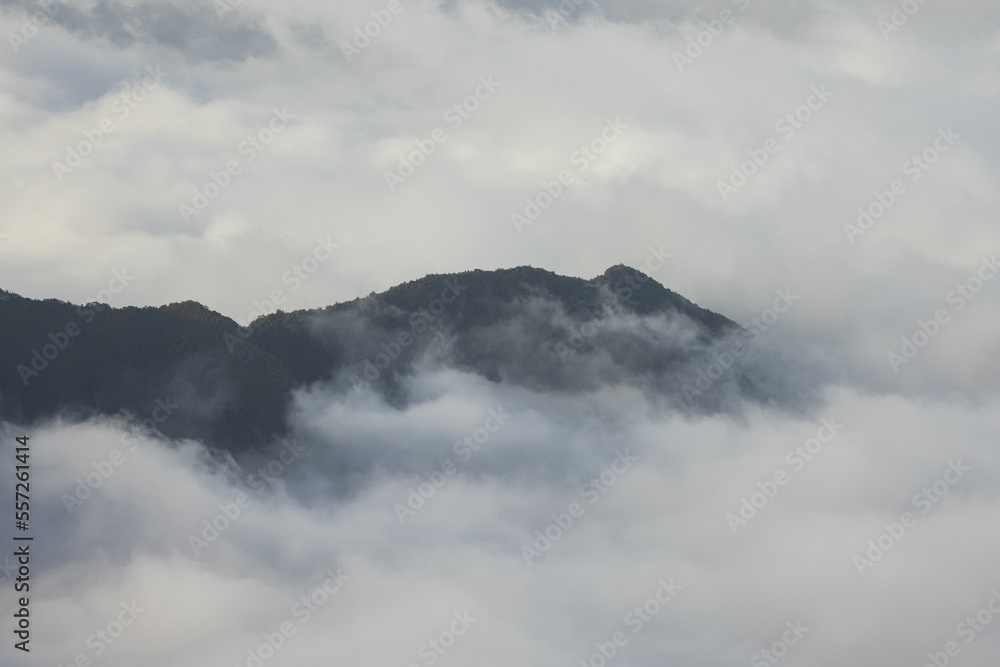 Obraz premium Stunning view of a high hill jutting out of the clouds on the volcanic island of Madeira in the Atlantic Ocean.