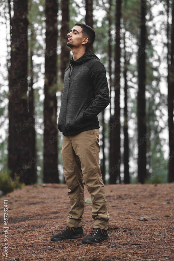 boy with black hair in the middle of the forest looking at the trees boy with black hair in the middle of the forest looking at the trees