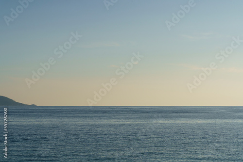 Clean seascape background with blue light evening sky and horizon. Summer evening sea after sunset or before sunrise. Tranquility, relaxation, silence concept.