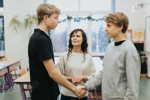 Teacher talks at school with two conflicted teenage boys