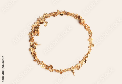 Gold (bronze) glitter empty ring circle frame on beige gray paper background. Abstract copy space texture.