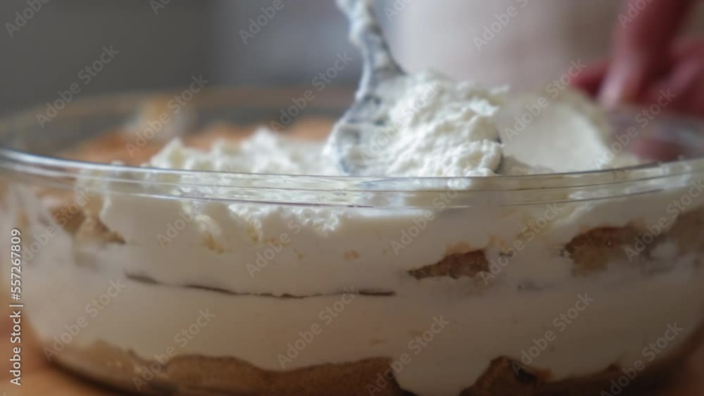 the process of cooking tiramisu. the cook lays out and smears