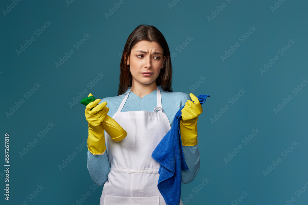 frowning woman cleaner apron with cleaning rag and detergent sprayer frowning woman cleaner apron with cleaning rag and detergent sprayer