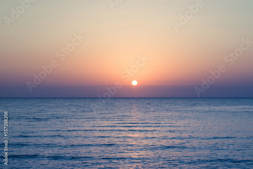 Beautiful sunrise at sea. Dawn on the Red Sea. The sun is reflected in the sea. Palm trees and palm leaves against the background of the rising sun. Tropical sunrise © decorator